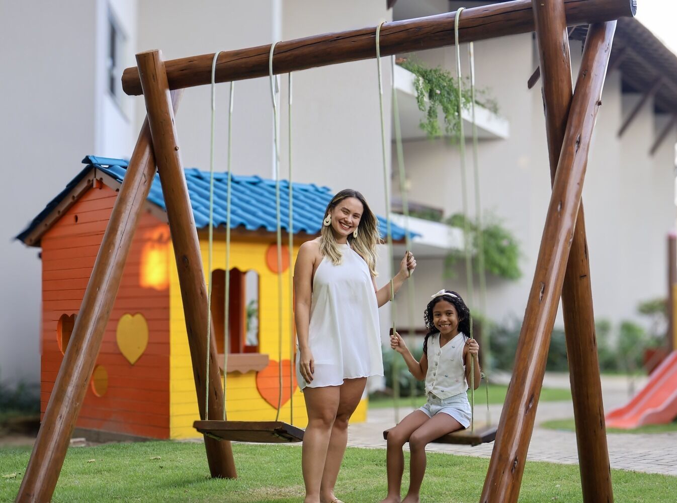 Un columpio de madera con un niño y un adulto.