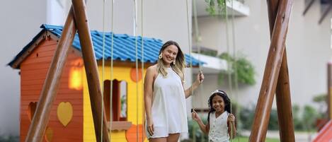 Un columpio de madera con un niño y un adulto.