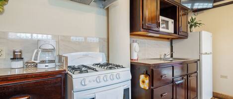 A kitchen with a stove, microwave, and refrigerator.