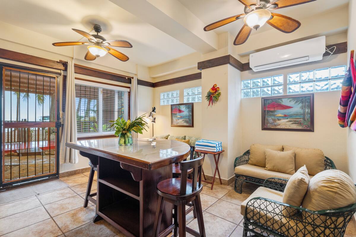 A dining area with a wooden table, chairs, and ceiling fans.