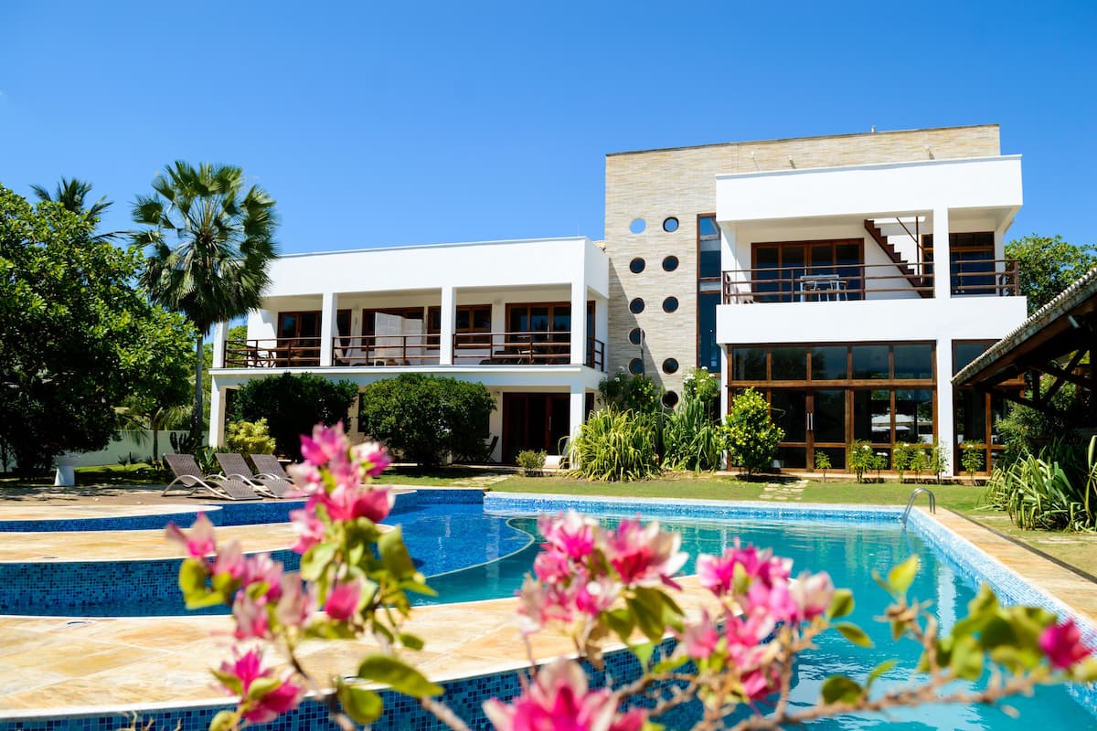 A modern two-story building with a swimming pool and outdoor seating.
