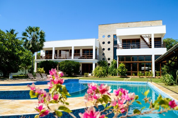 A modern two-story building with a swimming pool and outdoor seating. - Refúgios Parajuru (Beberibe)