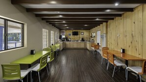 A restaurant with wooden walls and a long counter. There are multiple tables and chairs. - Budget Lodge Ruidoso (Ruidoso)