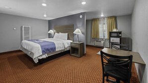 A hotel room with a bed, bedside tables, a desk, and a chair. - Budget Lodge Ruidoso (Ruidoso)