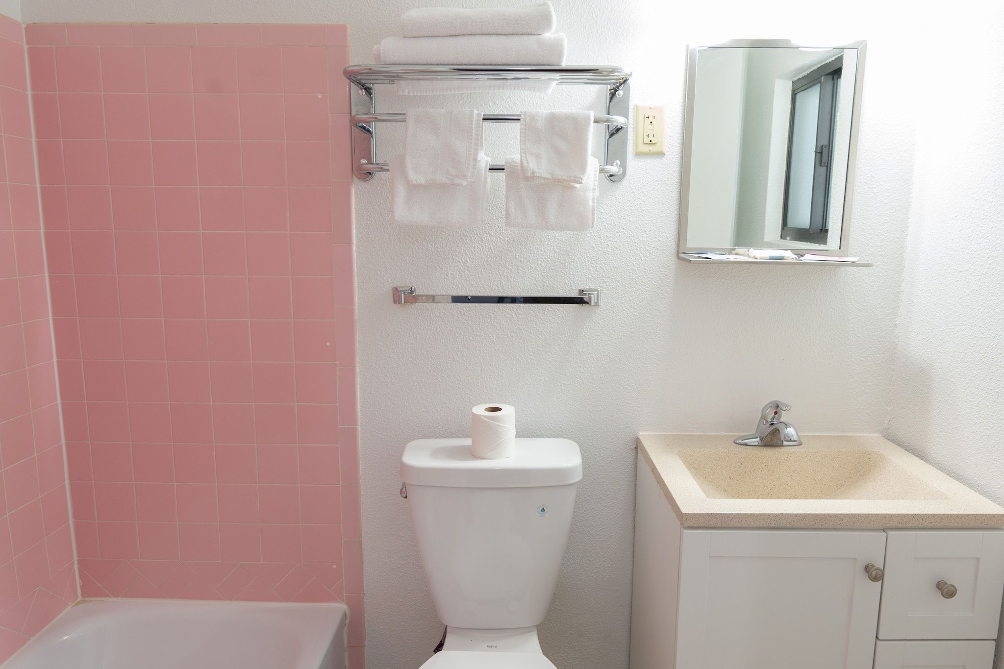 Une salle de bain équipée de toilettes, d’un lavabo et d’un porte-serviettes.