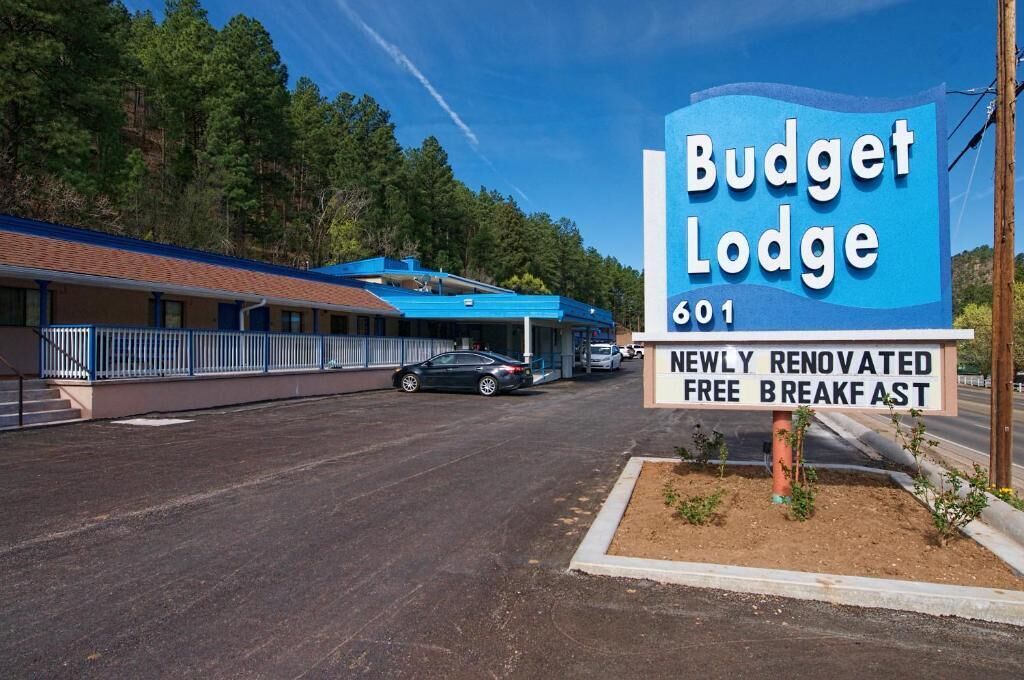 A Budget Lodge sign with a number 601 and mentions a newly renovated free breakfast.