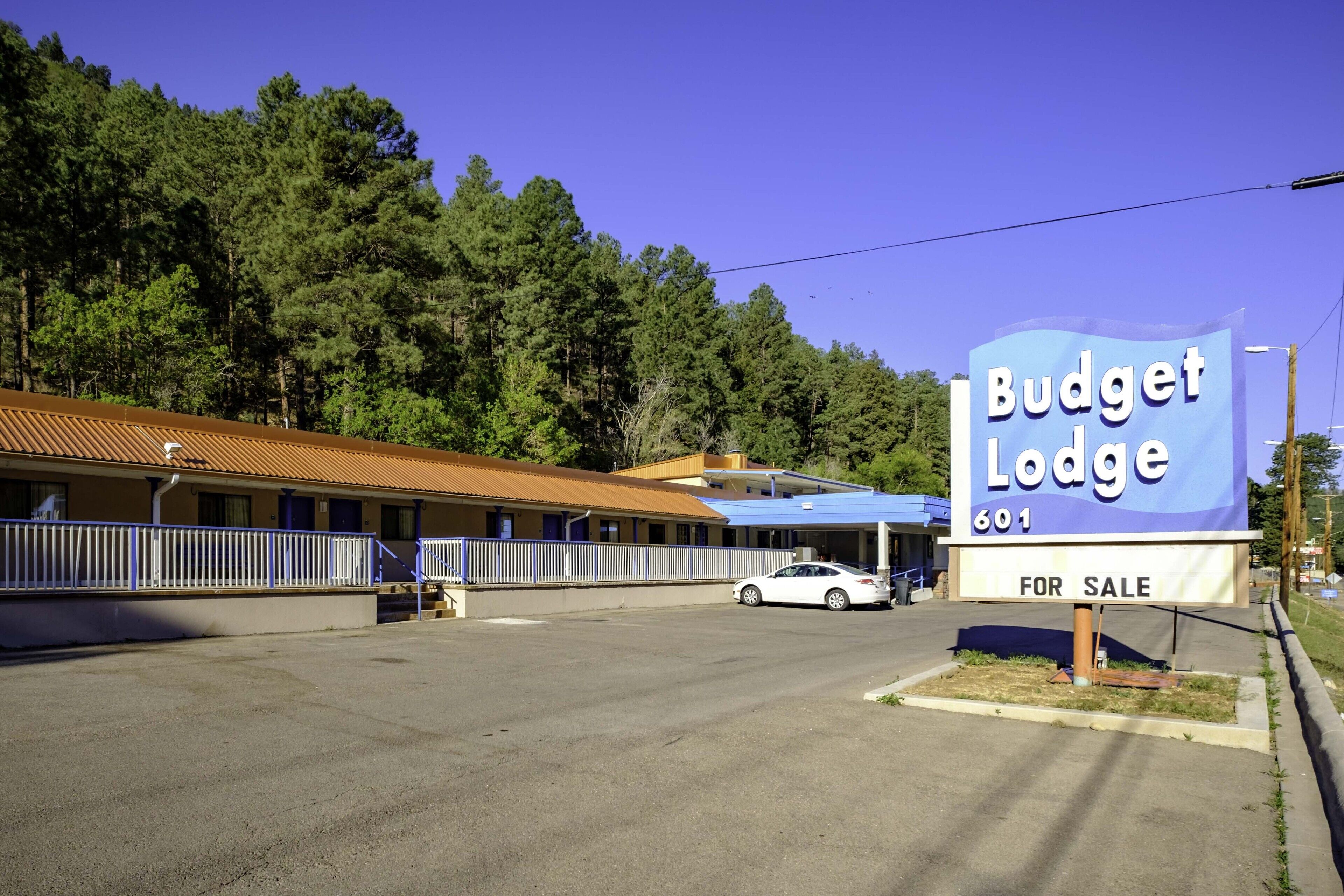 Motelli nimeltä Budget Lodge, jonka kyltissä ilmoitetaan, että se on myynnissä.