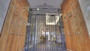 A wooden double door with a decorative metal gate. - Hotel Boutique La Artillería (Cartagena)