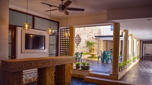 A spacious indoor area with a stone counter, ceiling fan, and hanging pendant lights. - Hotel Boutique La Artillería (Cartagena)