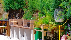 Una construcción de ladrillo con un contenedor verde y una jaula de metal.