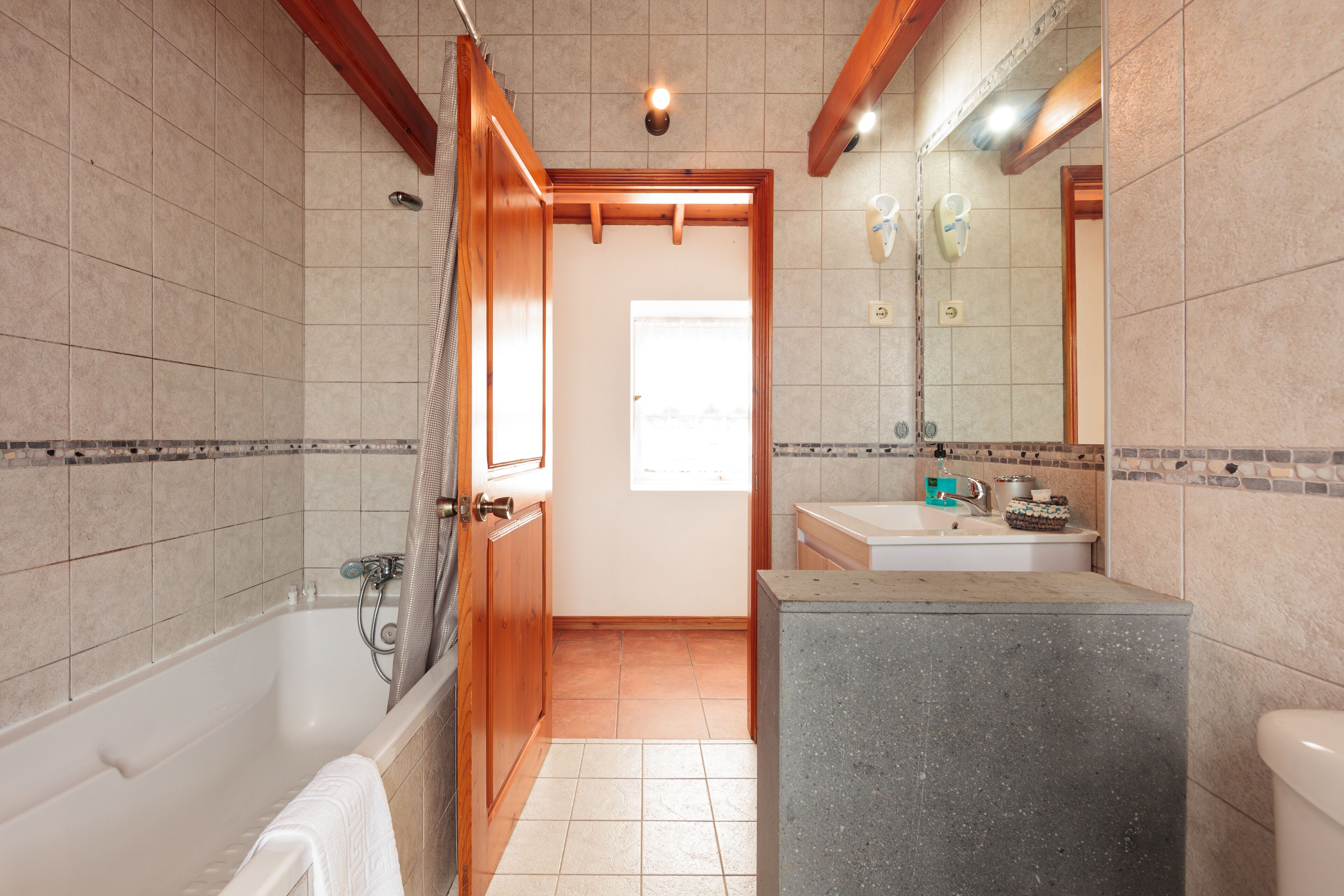 A bathroom with a bathtub, a shower, a sink, and a toilet.