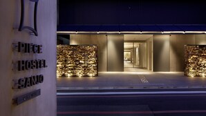 A modern hotel entrance with illuminated signage and a well-lit interior visible through the glass doors. - Piece Hostel Sanjo (Kyoto)
