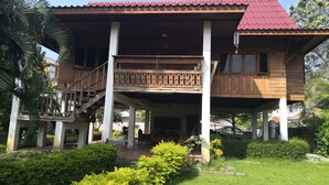A wooden house with a red roof, a balcony, and a covered porch area. - GongKaew HuenKum Hotel (Chiang Mai)