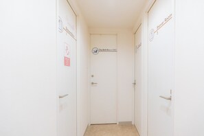 A narrow hallway with doors labeled 'Shower Room 1' and 'Shower Room 3' and a 'Pay Bath Room' sign. - Grand Hostel LDK Sapporo (Sapporo)