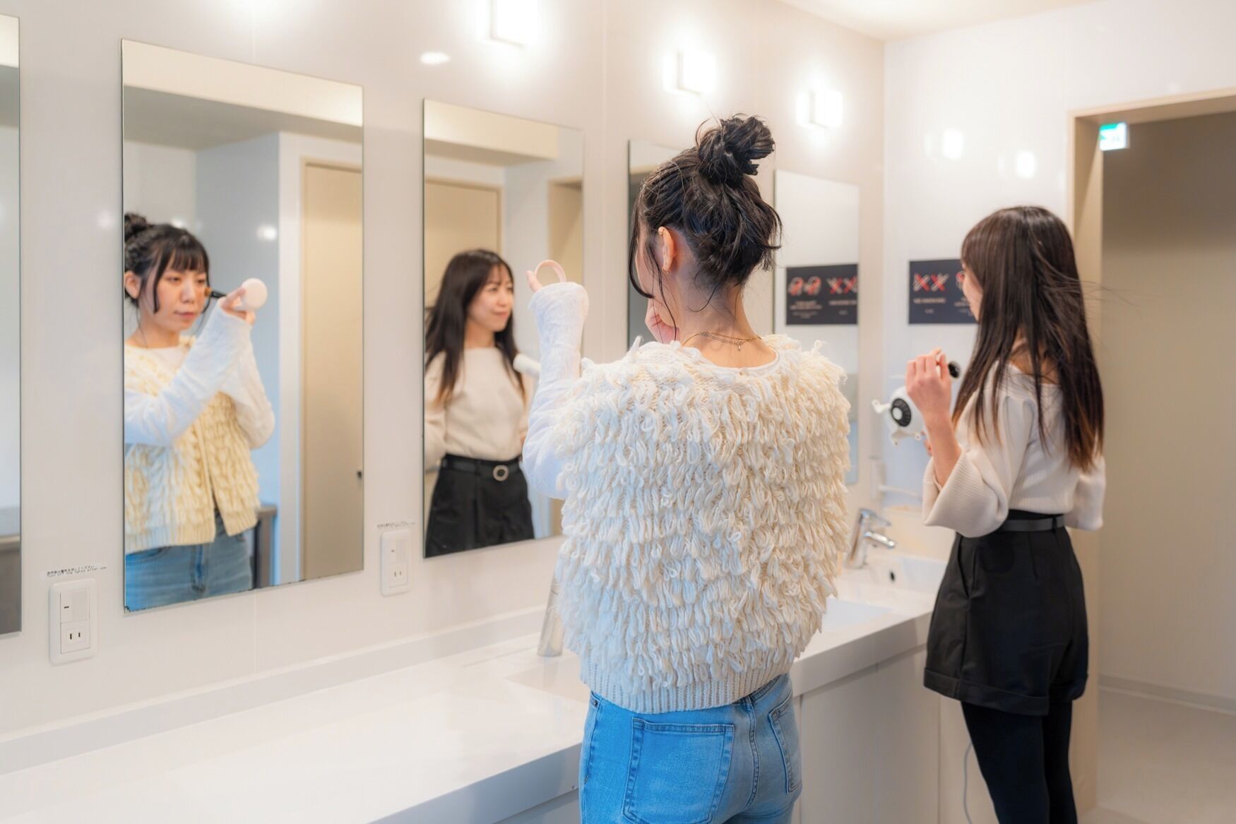 A bathroom with a large mirror, a sink, and a hairdryer.