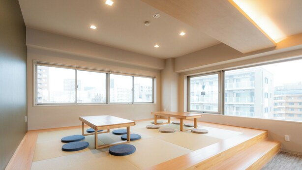 Una habitación con suelo de tatami, una mesa de madera y un banco.
