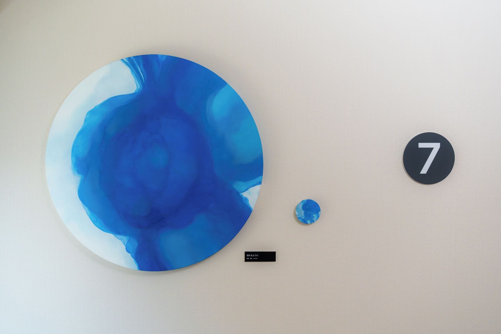 A wall with a large circular artwork and a small number '7' sign.