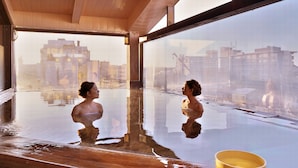 A large indoor pool with a clear view of the cityscape through the windows. - Awara Grand Hotel (Awara)