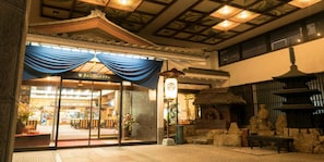 A traditional Japanese building with a wooden structure, a thatched roof, and a stone lantern. - Awara Grand Hotel (Awara)