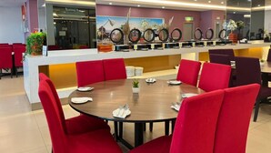 A restaurant with red chairs, a round table, and a counter with decorative rings. - Puteri Bay Hotel Melaka (Malacca City)