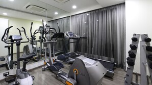 A gym with various exercise equipment, including treadmills, elliptical machines, and weight machines. - The Lime Boutique Suites (Hyderabad)