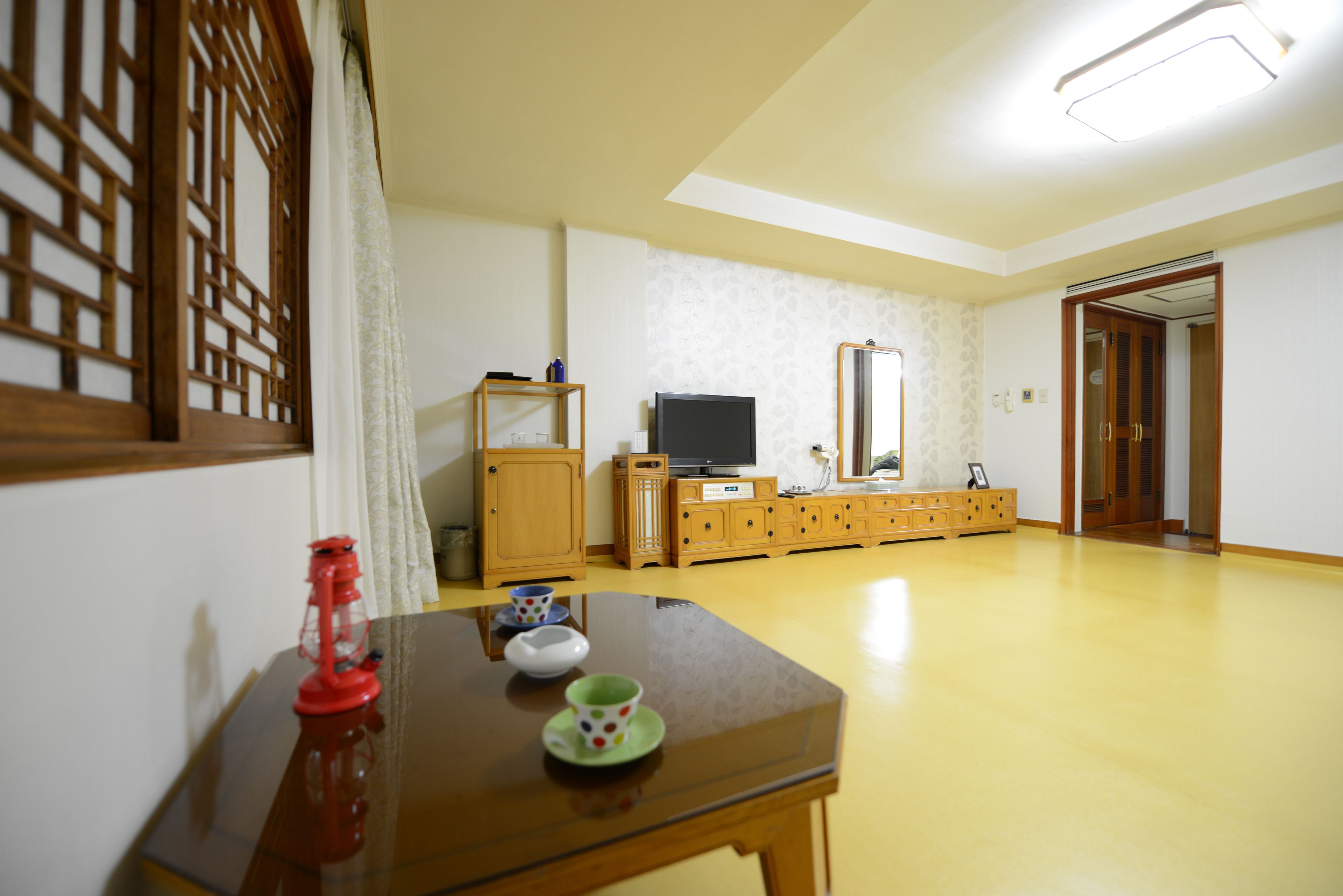 A room with a wooden table, a television, and a cabinet.