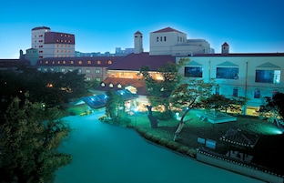 Un hotel con varias edificaciones, un patio interior y un pequeño puente.