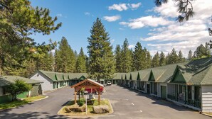 A row of motel cabins with green roofs and a central gazebo. - Green Gables Motel & Suites (Burney)