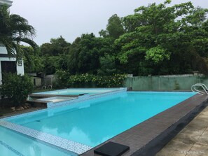 Una piscina al aire libre, sillones reclinables de piscina