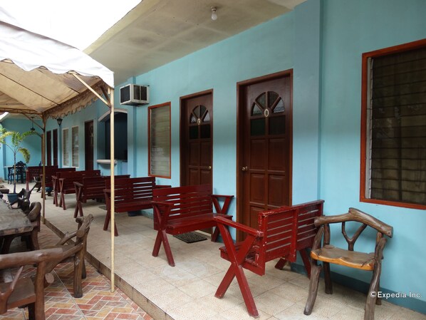 A building with blue walls, wooden benches, and a tiled floor. - Circon Businessman's Inn (Puerto Princesa)