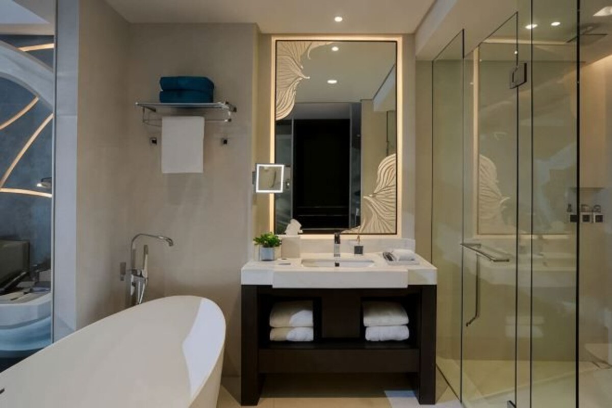 A modern bathroom with a freestanding bathtub, a glass shower enclosure, and a vanity with a mirror.
