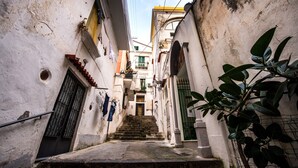Une ruelle étroite avec un escalier menant à l’entrée d’un immeuble.