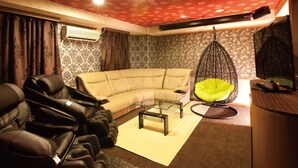 A living room with a sofa, a hanging chair, and a massage chair. - Hotel Dessert Hills - Adults only (Kyoto)
