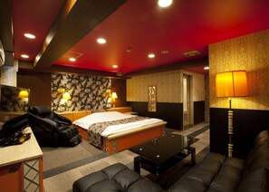 A hotel room with a bed, a massage chair, a desk, a sofa, and a lamp. - Hotel Dessert Hills - Adults only (Kyoto)