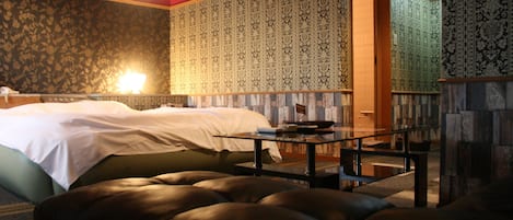 A hotel room with a bed, a table, and a seating area.
