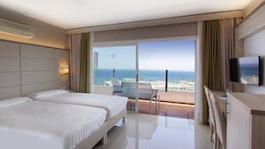 A hotel room with two beds, a TV, and a balcony with a view of the sea. - Bull Escorial & Spa (San Bartolomé de Tirajana)