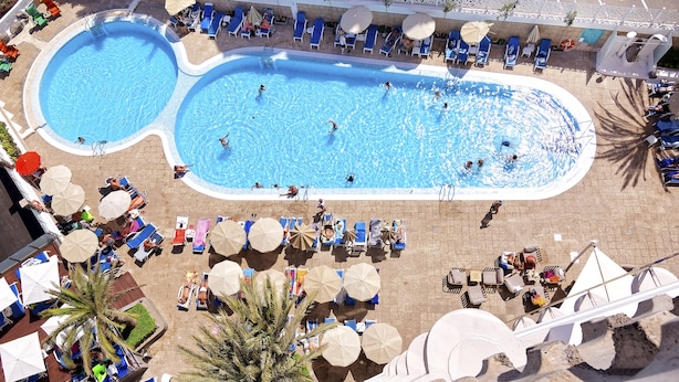 A large outdoor swimming pool with multiple lanes, surrounded by sun loungers and umbrellas. - Bull Escorial & Spa (San Bartolomé de Tirajana)