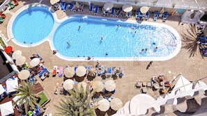 A large outdoor swimming pool with multiple lanes, surrounded by sun loungers and umbrellas. - Bull Escorial & Spa (San Bartolomé de Tirajana)