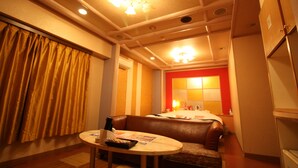 Habitación de hotel con zona de estar, una mesa y kitchenette.