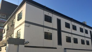 Un edificio de varios pisos con fachada blanca, marcos de ventana negros y techo plano.