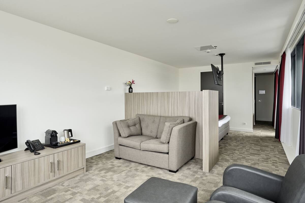 Ein modernes Wohnzimmer mit Sofa, Couchtisch, Fernseher und Schrank.