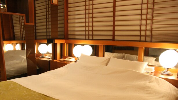 A hotel room with a large bed, bedside lamps, and a mirror above the bed. - Hotel Parco - Adults only (Kyoto)