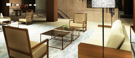 A modern lobby with wooden furniture, marble flooring, and a large floor lamp.