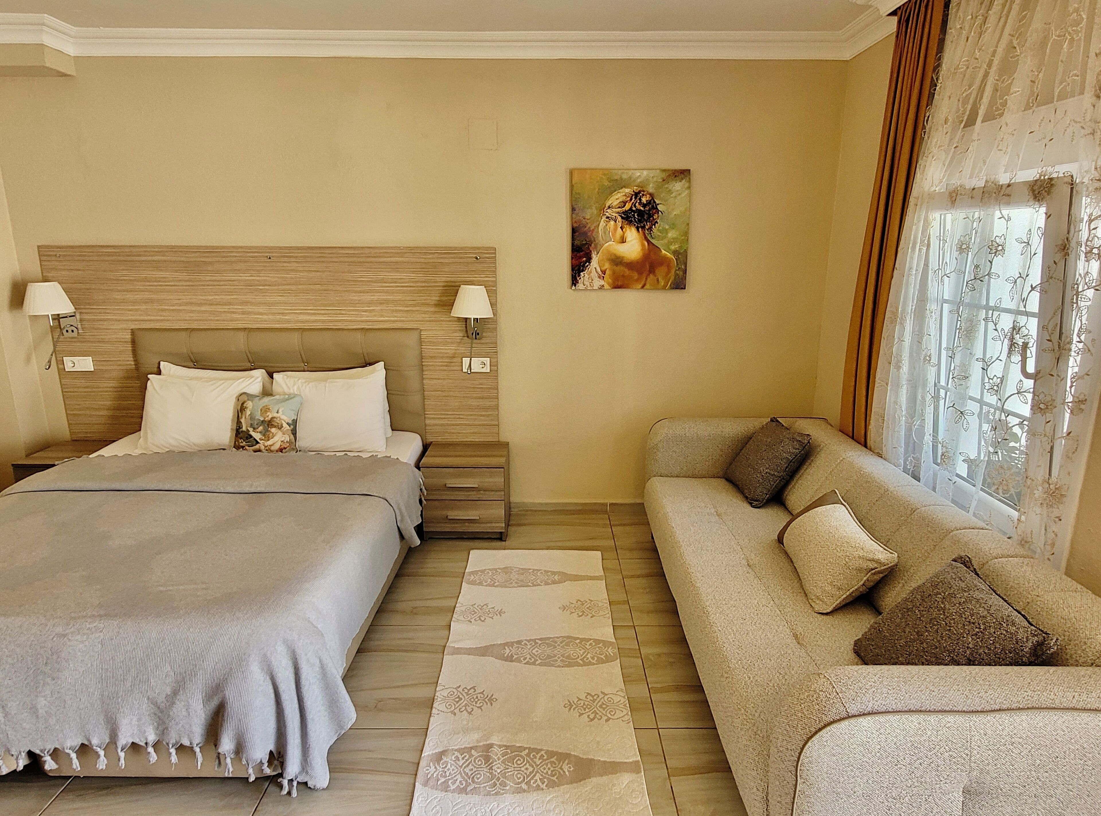 Une chambre d’hôtel avec un grand lit, un canapé et un tableau au mur.