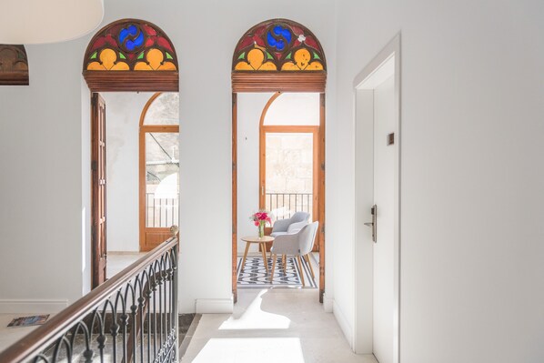 A hallway with a staircase, a wooden door, and a seating area with a table and chairs. - Bordoy Mostatxins - Hotel Boutique Adults Only (Alcúdia)