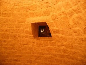 Un muro de piedra con un ventanal pequeño.
