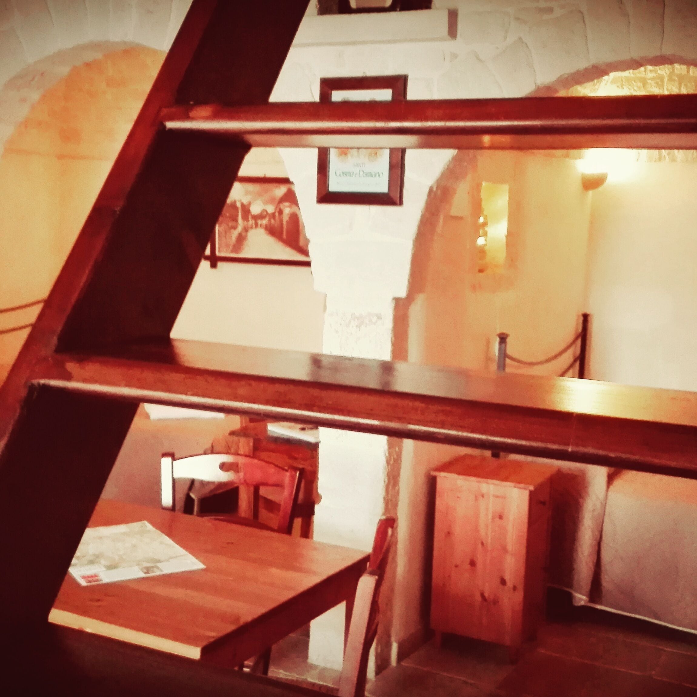 Una habitación con una mesa y sillas de madera, un mueble pequeño y un cuadro en la pared.
