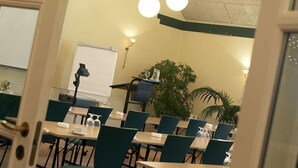 A conference room with tables and chairs, a whiteboard, and a projector. - Hotel Smedegaarden (Lem)
