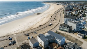 An aerial view of a coastal town with a beach, roads, and buildings. - Atlantic Motel (Hampton)