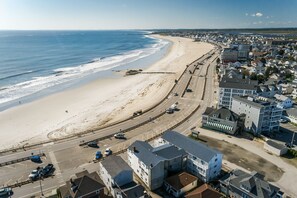 An aerial view of a coastal town with a beach, roads, and buildings. - Atlantic Motel (Hampton)